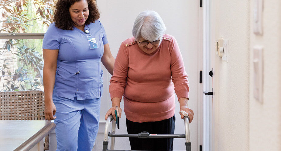 nurse helps patient with walker at home
